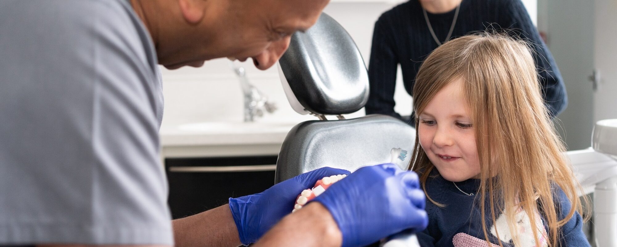Girl learning how to correctly brush teeth